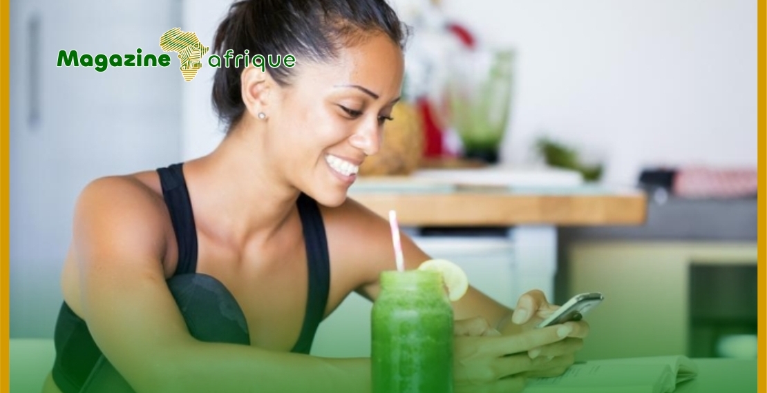 A young lady resting and taking a glass of fruit extract after exercise