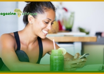 A young lady resting and taking a glass of fruit extract after exercise